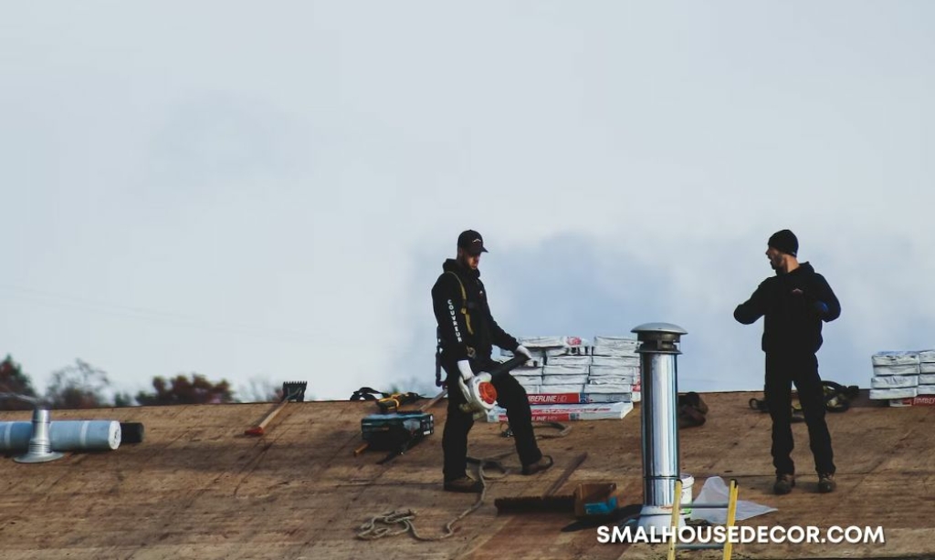 A Comprehensive Guide to Fixing Roofing Issues - a couple of men standing on top of a roof