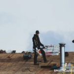 A Comprehensive Guide to Fixing Roofing Issues - a couple of men standing on top of a roof